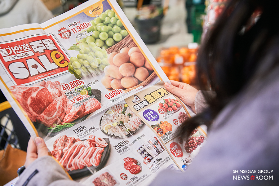 한 고객이 쇼핑 중 할인 전단을 확인하고 있다