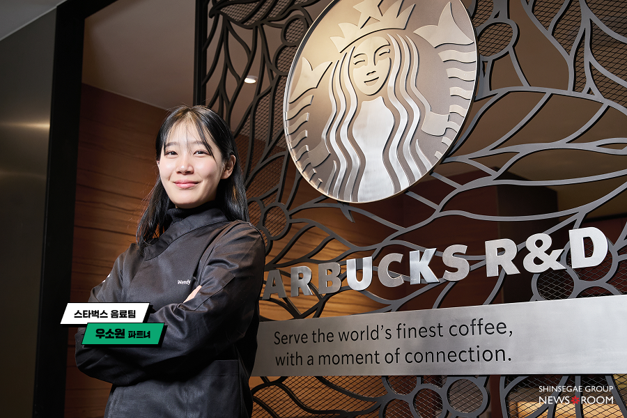 스타벅스 R&D 센터 로고 앞에서 포즈를 취하고 있는 음료팀 우소원 파트너의 모습