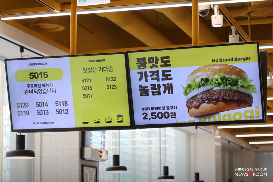 노브랜드 버거 매장 내부의 주문 현황판 화면. NBB 어메이징 불고기 2,500원 메뉴 홍보 문구와 준비 완료된 주문 번호 노출