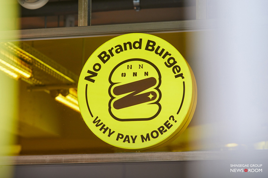 매장 창문에 붙은 노브랜드 버거(No Brand Burger)의 공식 로고와 WHY PAY MORE? 슬로건 이미지